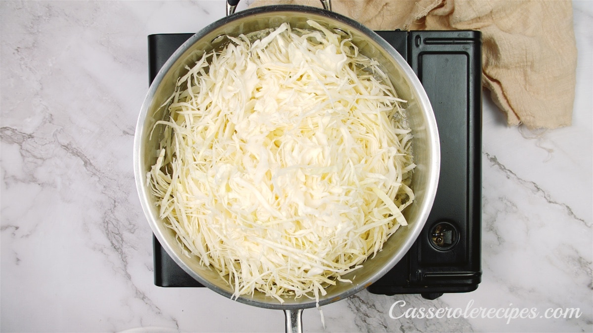 shredded cabbage added to the pan