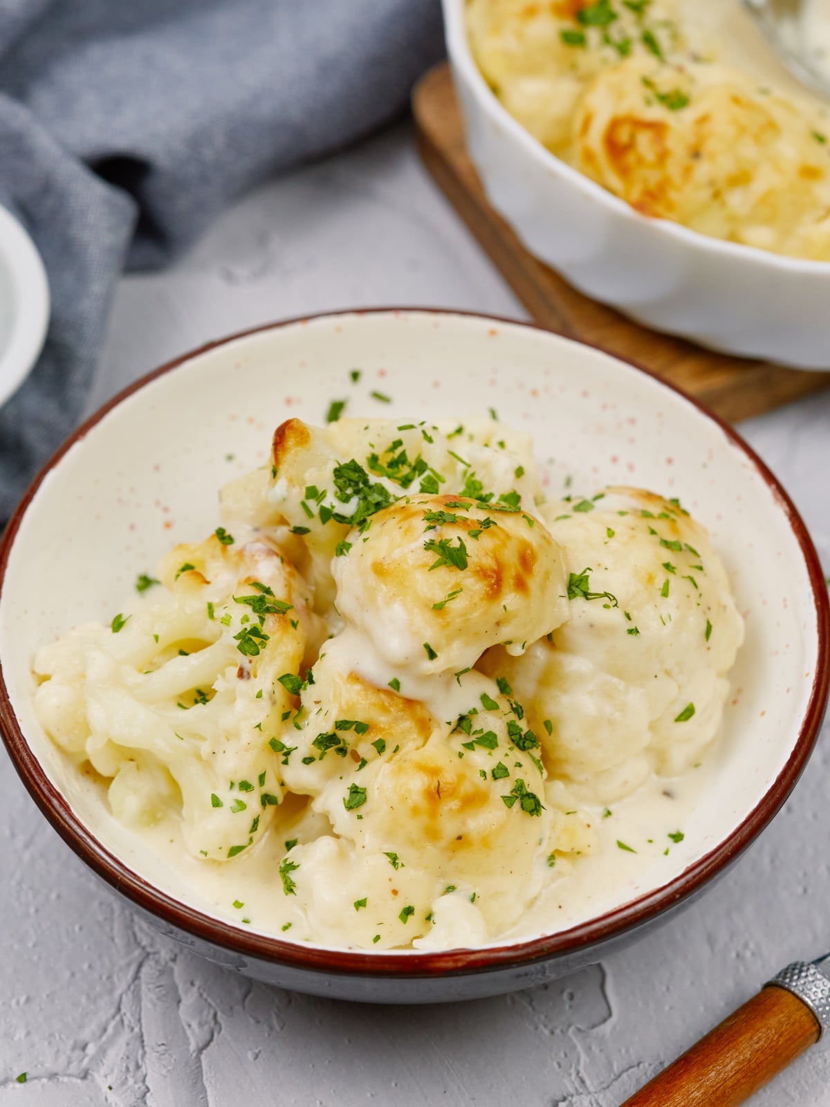 a bowl of cauliflower casserole on a white surface