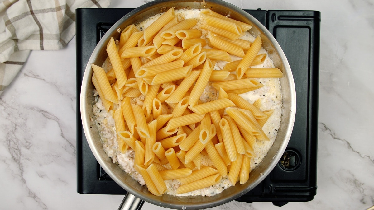 chicken mixture topped with uncooked penne pasta