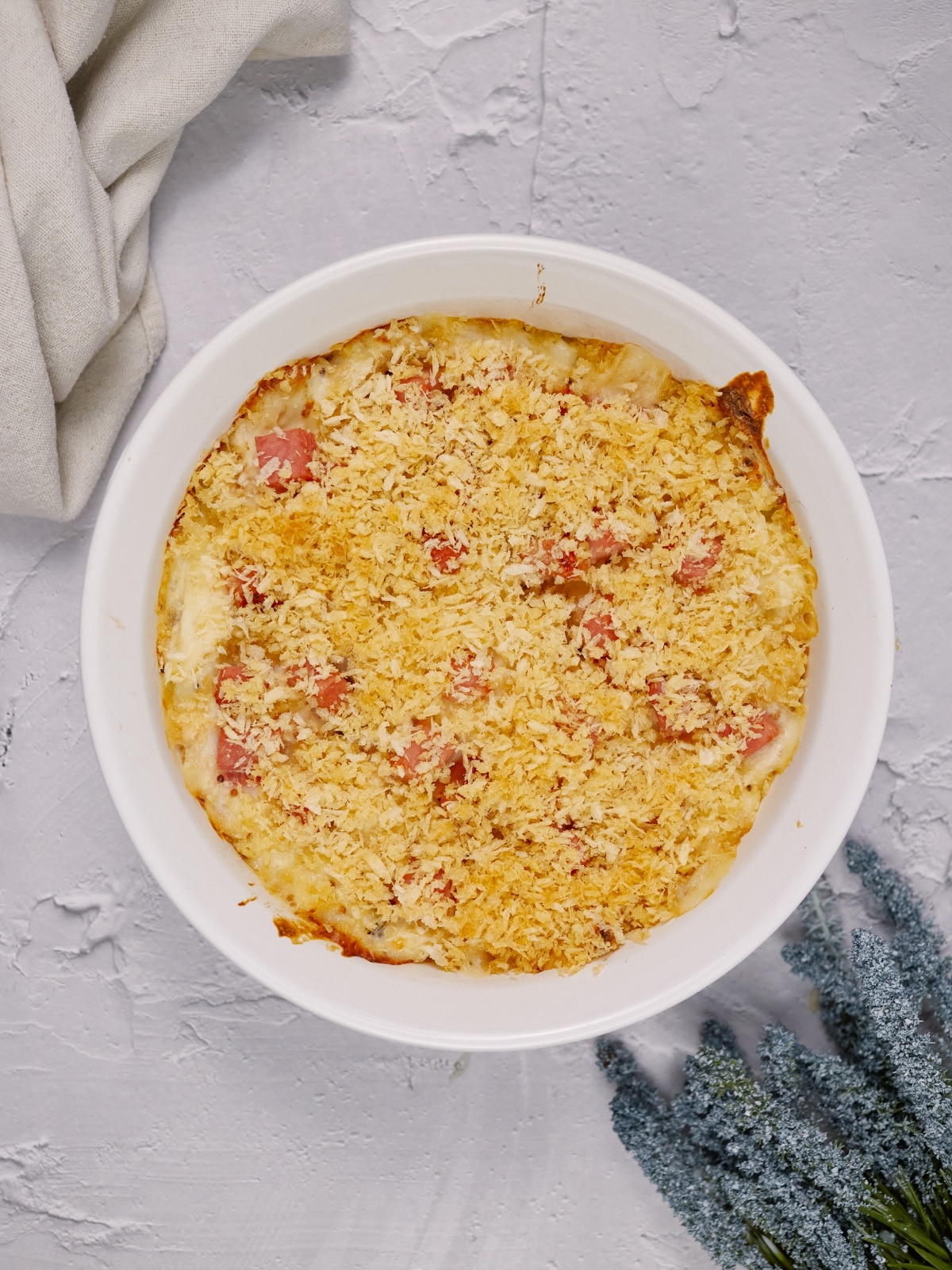 chicken cordon bleu casserole baked in a round dish and sitting on a white surface