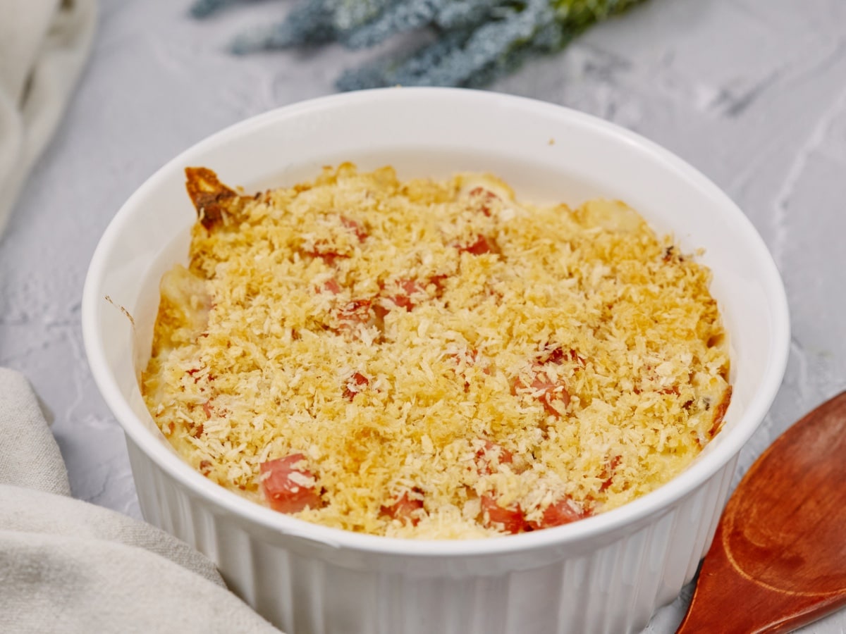 chicken cordon bleu casserole baked in a round dish and sitting on a white surface
