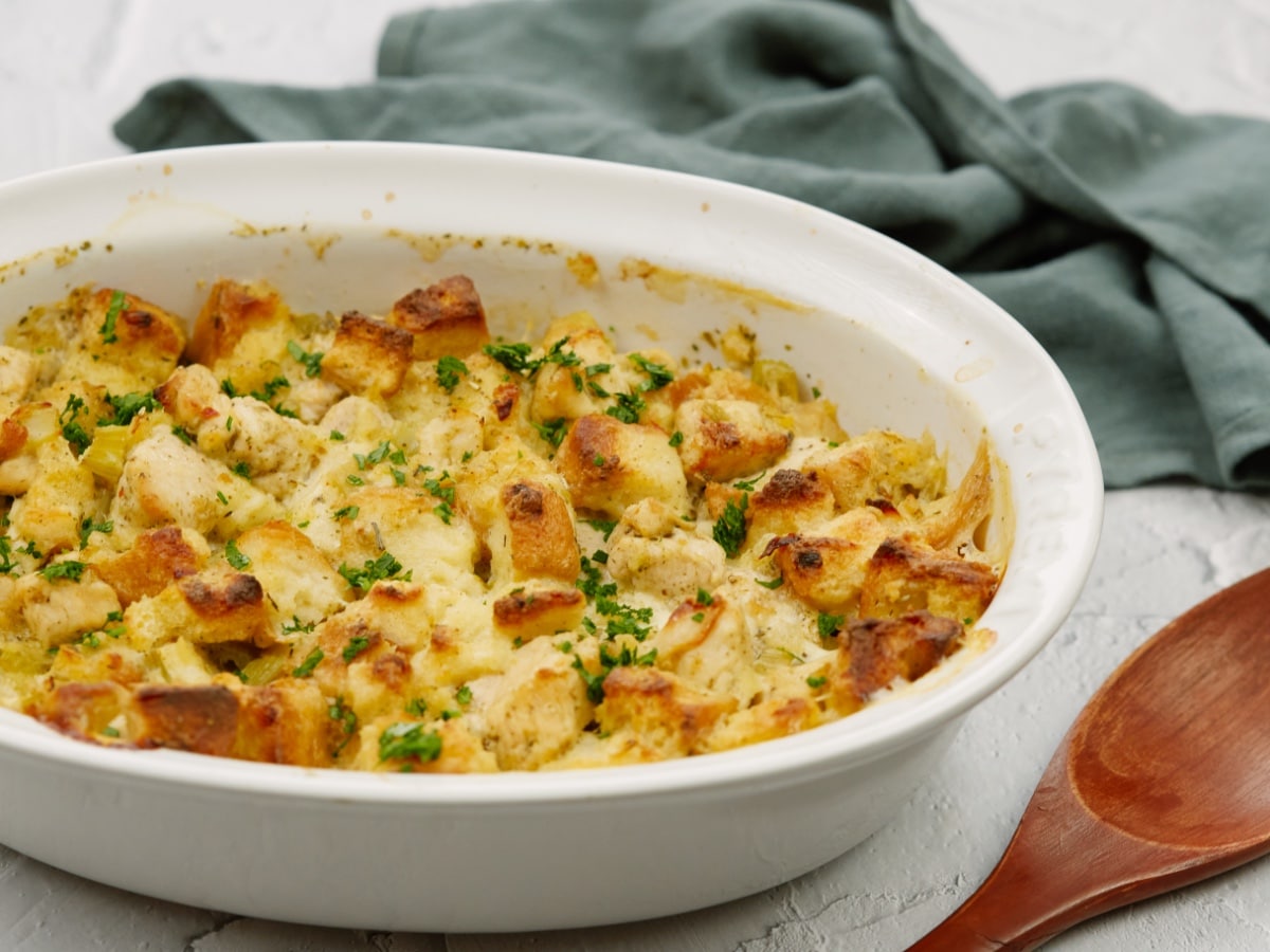 baked chicken stuffing casserole in a white baking dish on a white surface