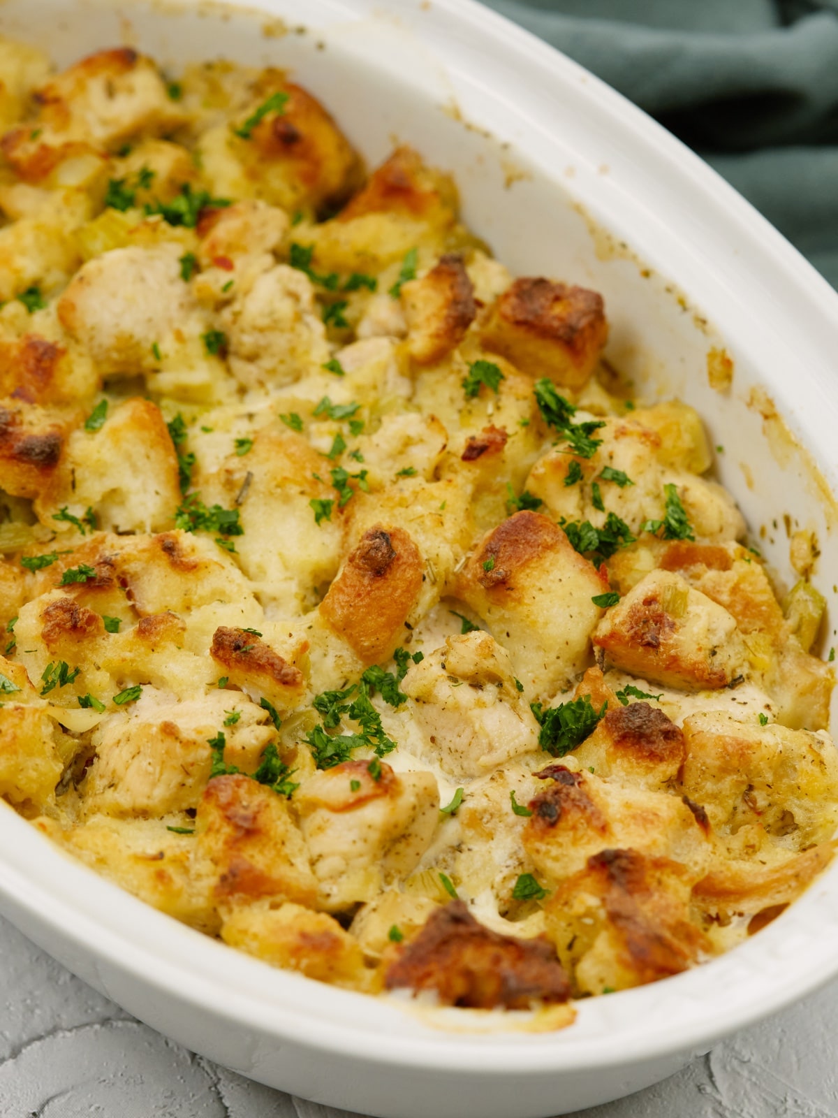 baked chicken stuffing casserole in a white baking dish on a white surface