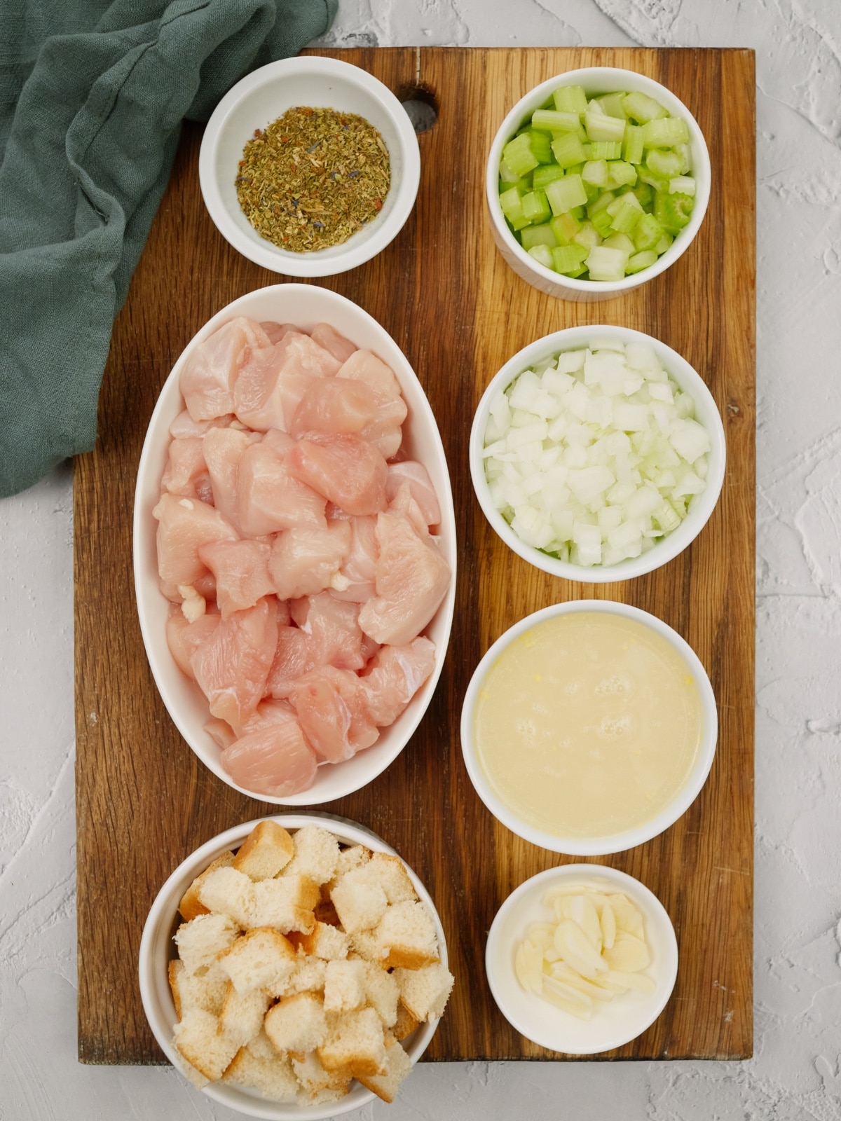 ingredients for chicken stuffing in small bowls on a cutting board