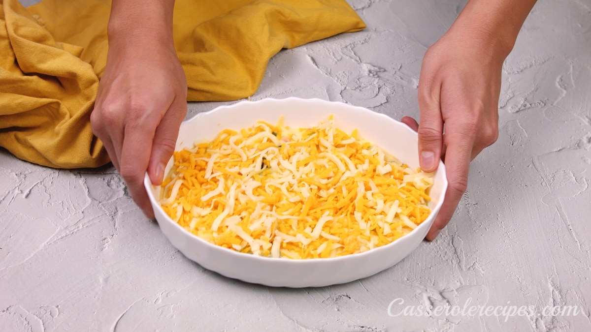 cheese mixture in a baking dish topped with shredded cheese