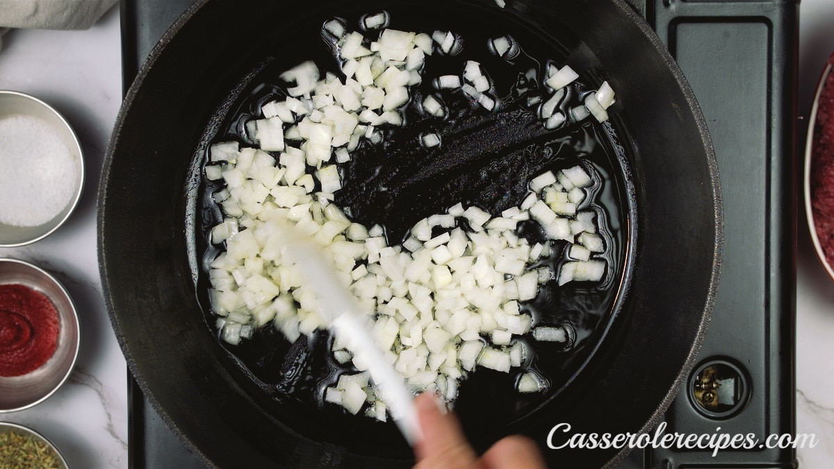 onions cooking in a black pan on a stove top