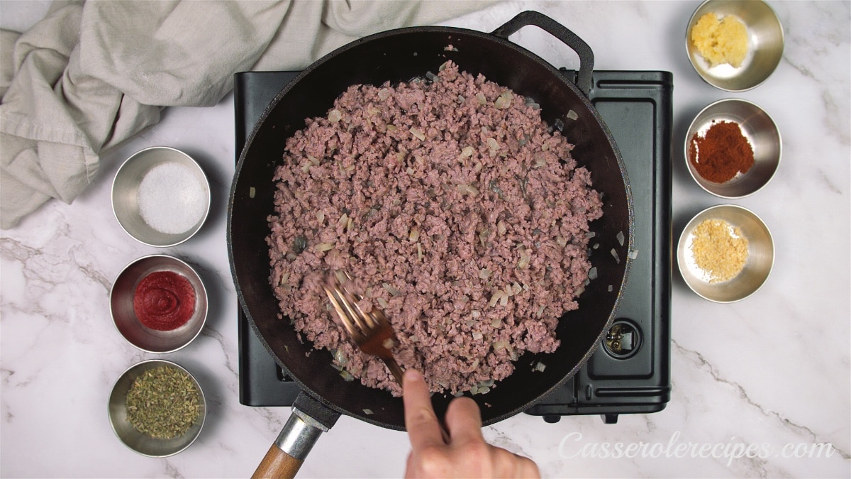 a pan of cooked ground beef on a stove top