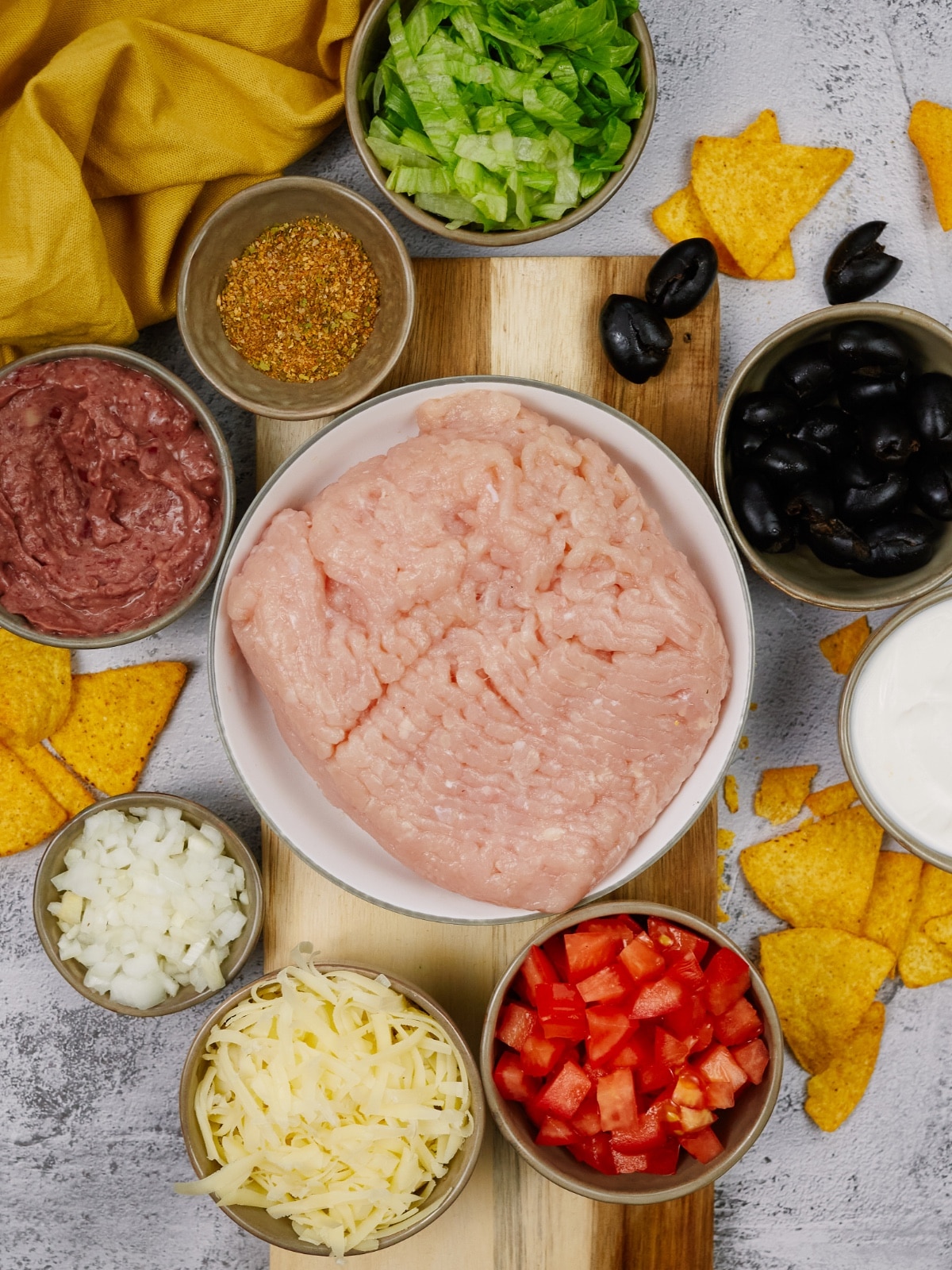 ingredients for Mexican casserole in bowls on a light colored surface
