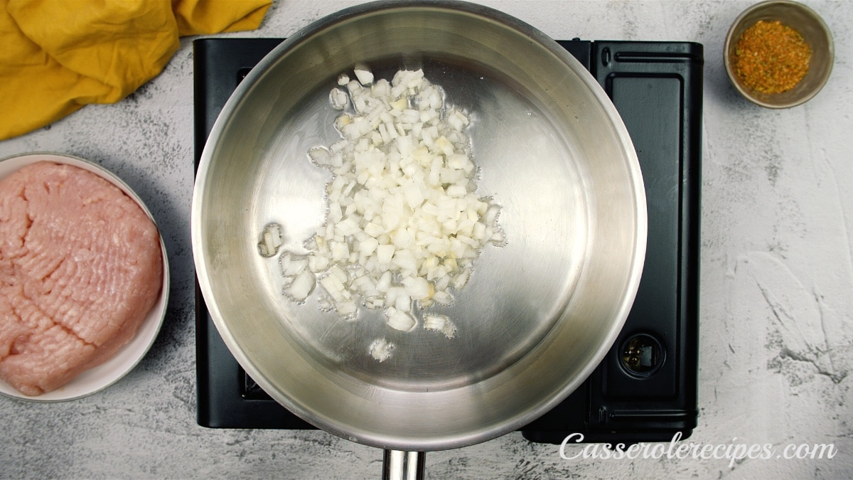 onions cooking in a saute pan on a stove top