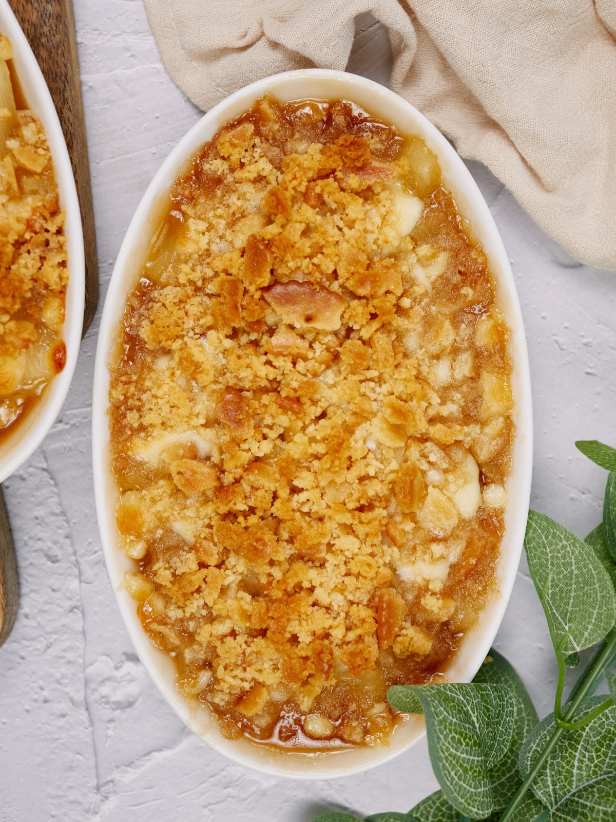 pineapple casserole in a white baking dish on a cutting board and white surface