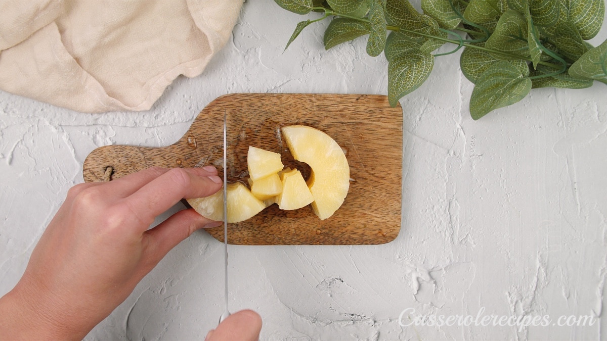 cutting the pineapples on a wooden cutting board