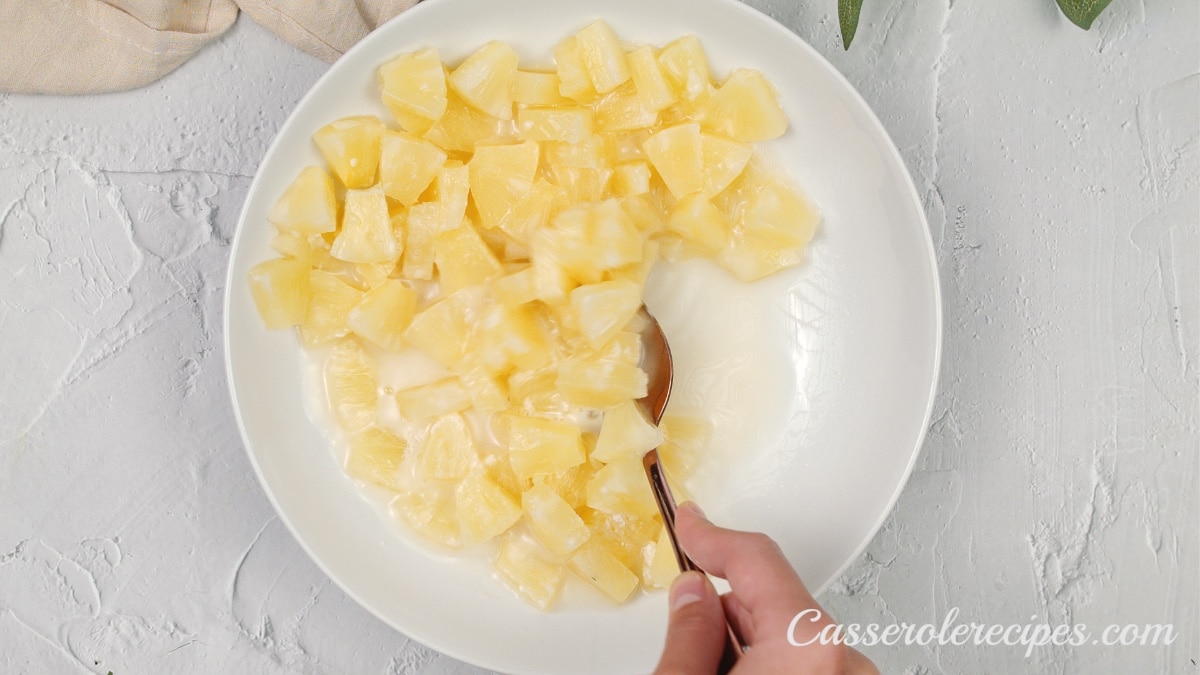 stirring the pineapple mixture with a spoon