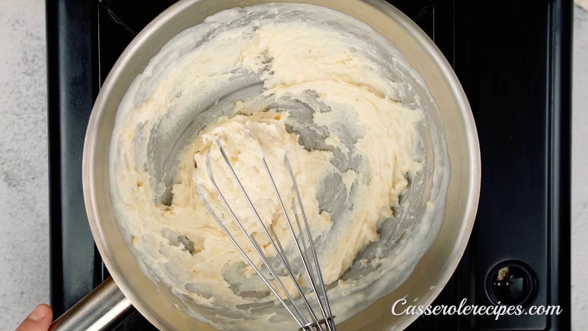 whisking butter, flour, and milk into a roux