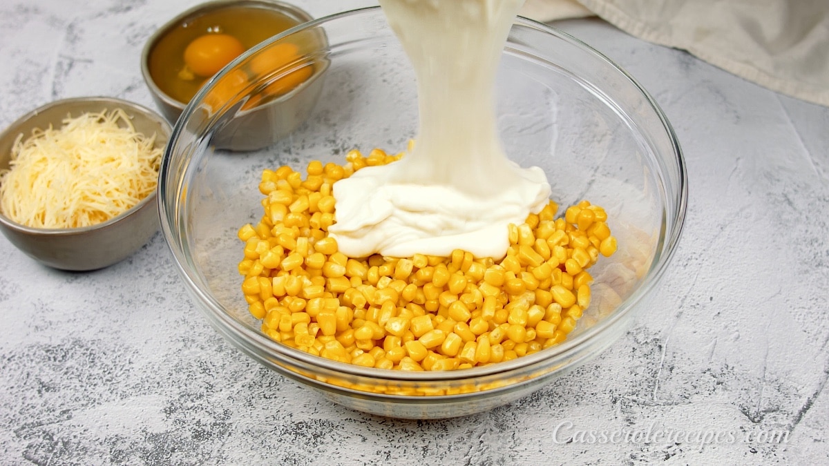 white sauce poured over corn in a glass bowl