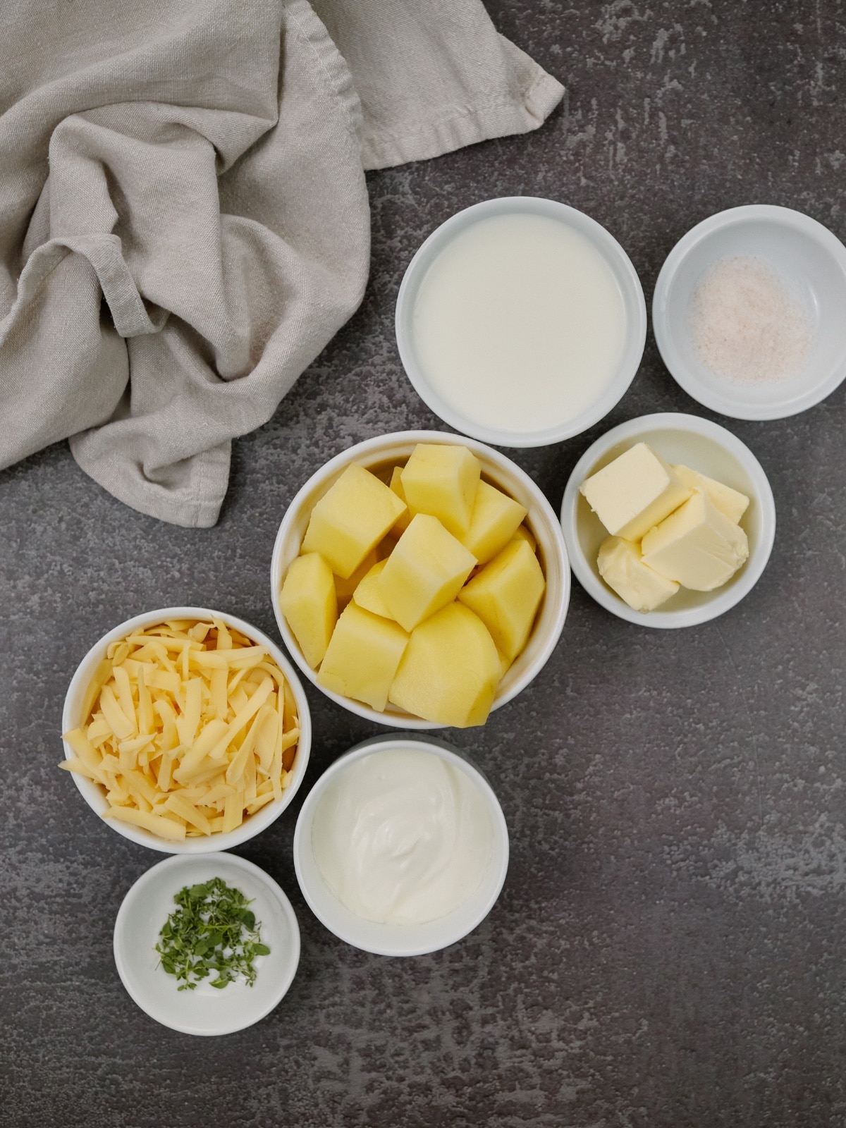 ingredients for mashed potato casserole in small white bowls