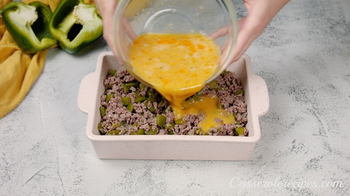 pouring egg mixture over beef in baking dish