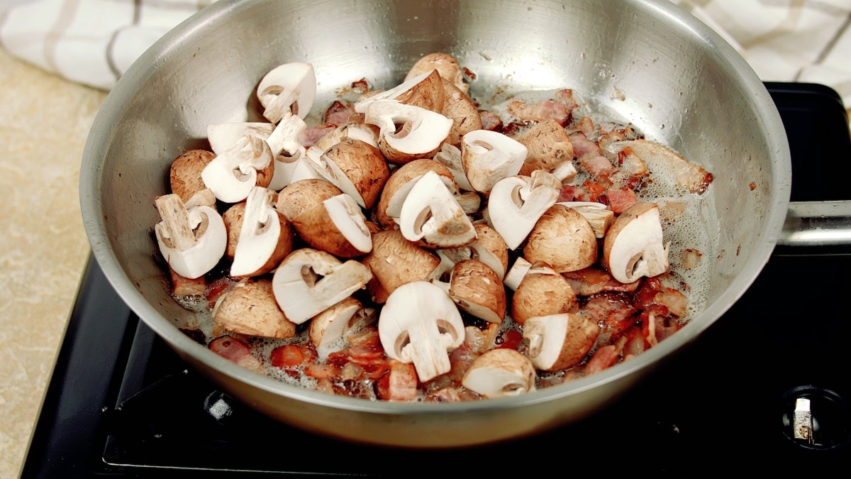 mushrooms added to bacon in the pan