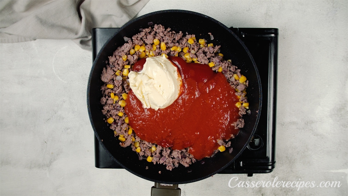 tomato sauce and cream cheese added to skillet with meat