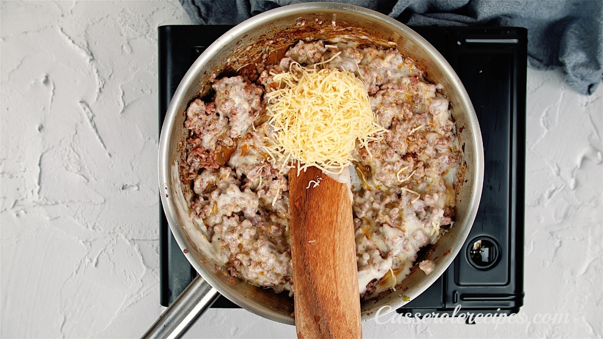 adding cheese to the ground beef mixture