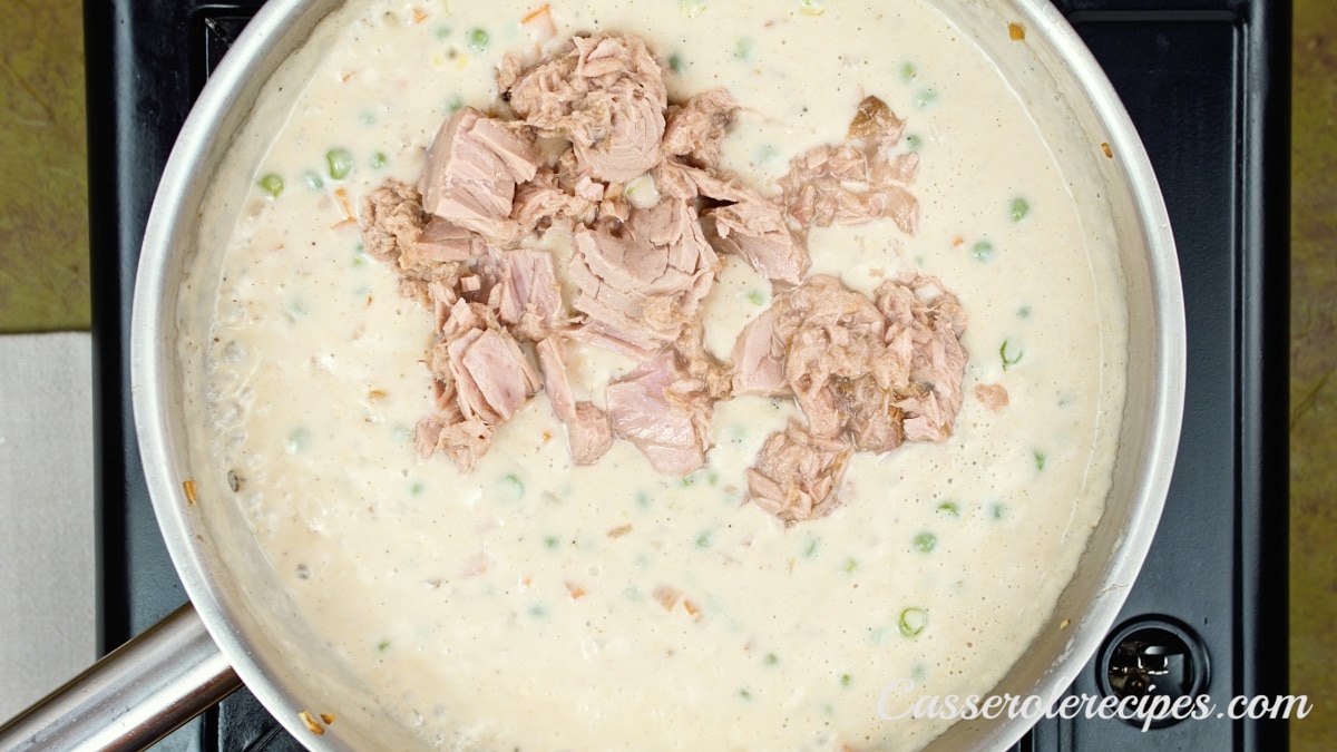 tuna fish added to a pan of creamy vegetables