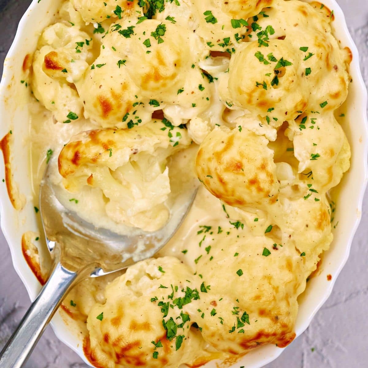 Cauliflower casserole in a white ceramic dish.