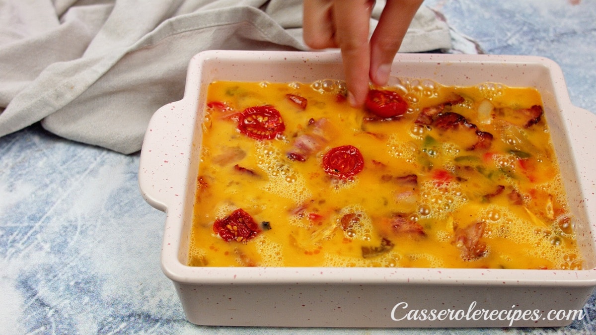 placing sliced, dried tomatoes on top of casserole