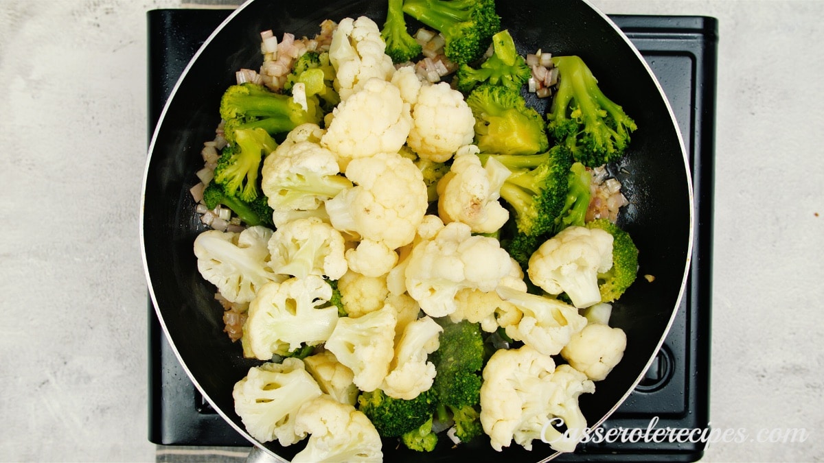 cauliflower on top of broccoli in a pan