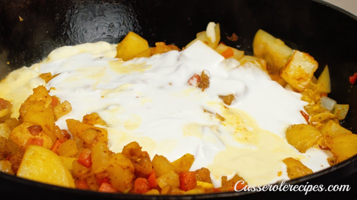 cream added to potatoes in pan
