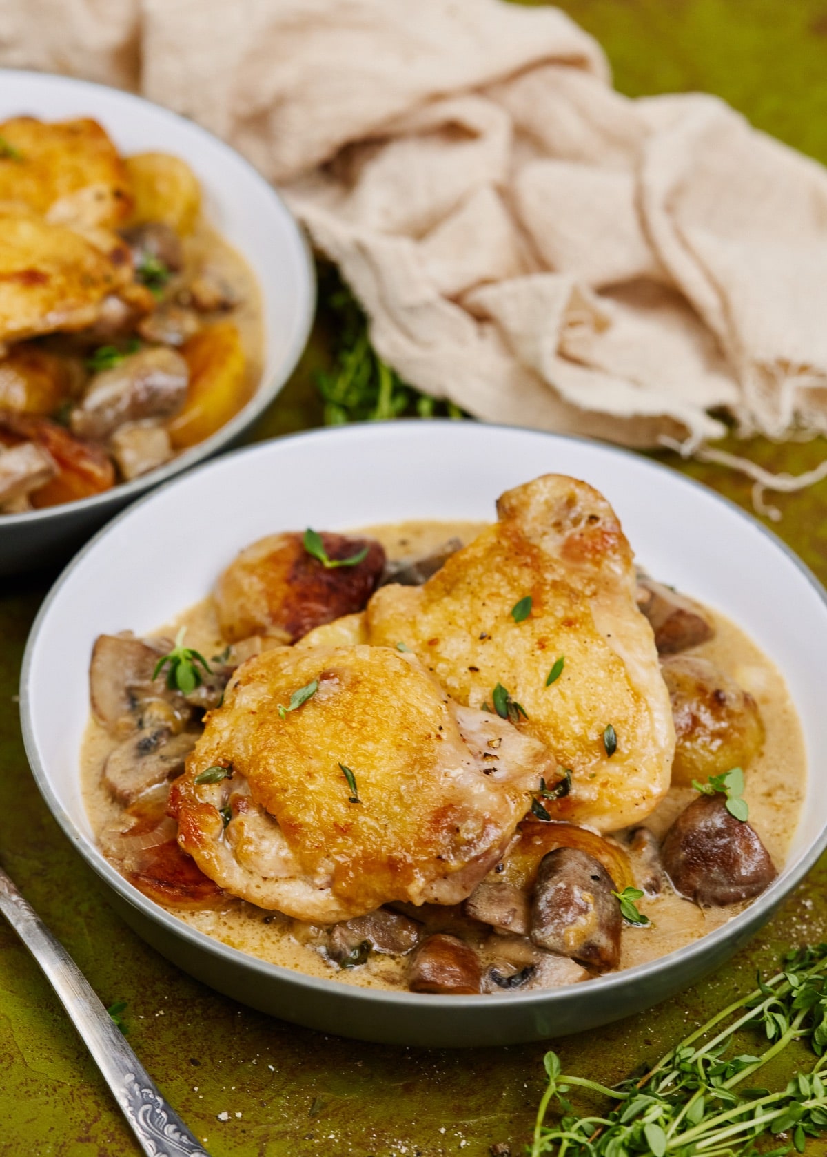 chicken thigh and mushrooms in white bowl