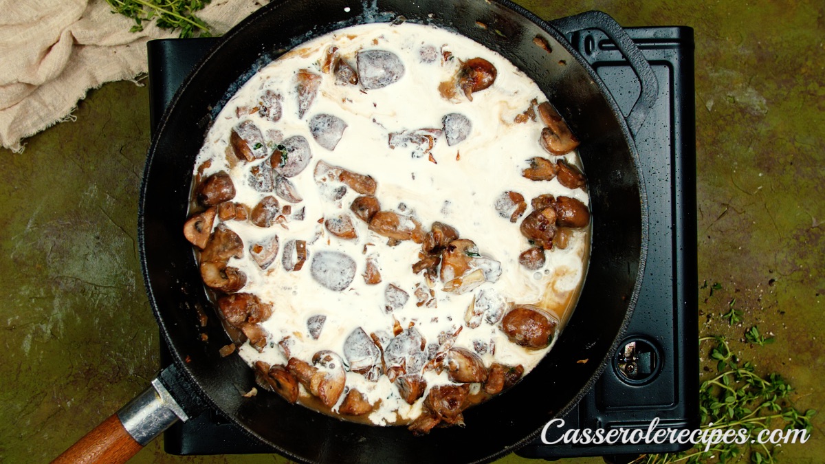 browned mushrooms in cream sauce in pan