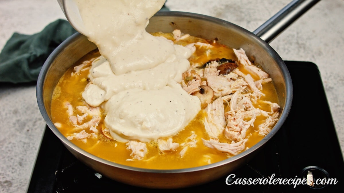 creamy sauce being poured over chicken and sauce