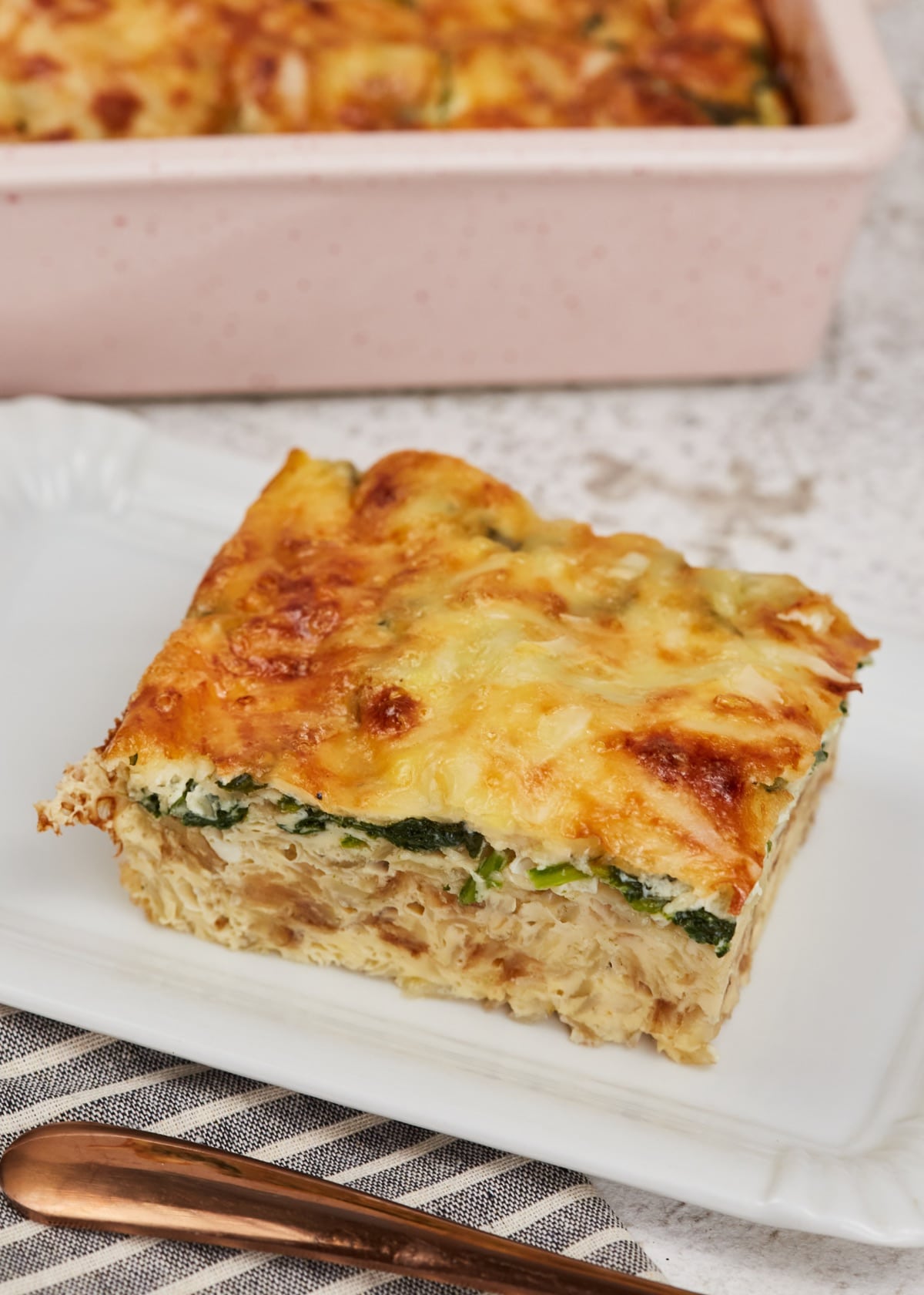 a slice of hashbrown spinach breakfast casserole on a white plate