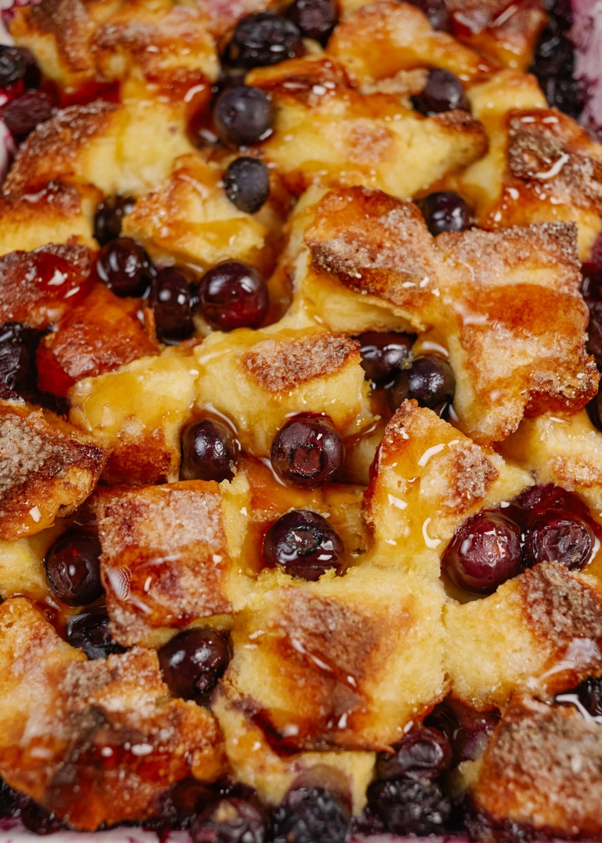 baked blueberry french toast casserole in a white baking dish on a wooden board