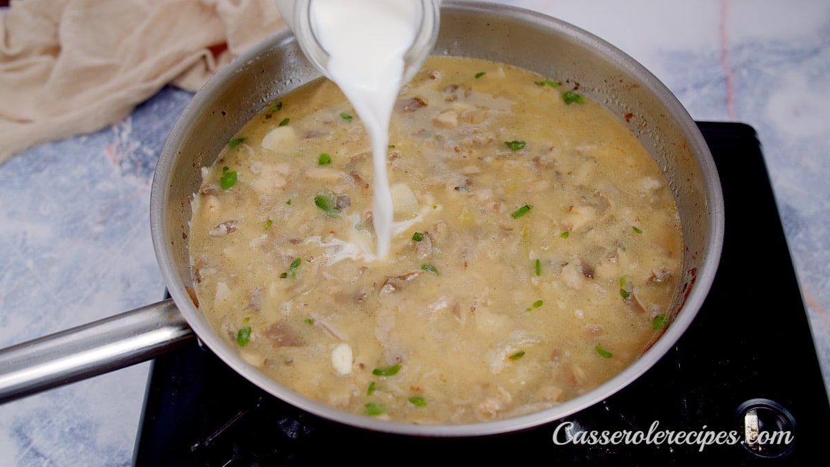 pouring cream into pan with mushrooms and onions