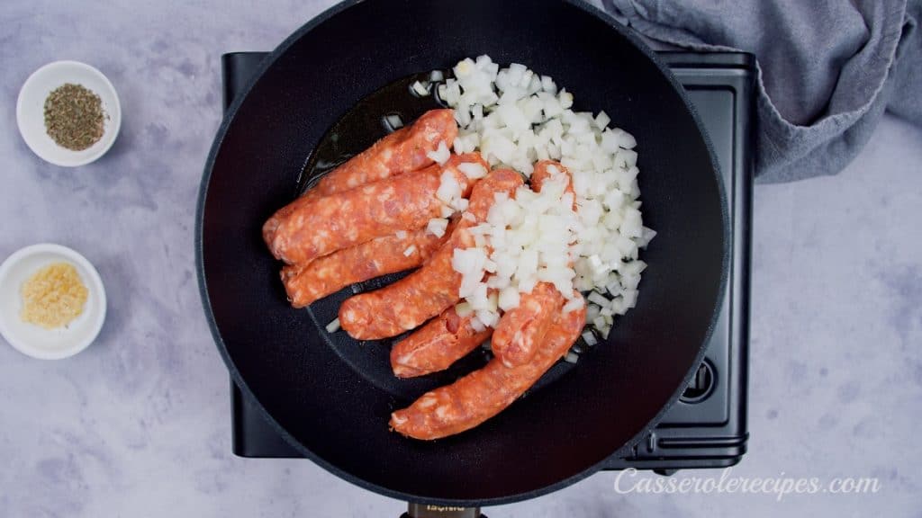 chorizo sausages and onions in a saute pan
