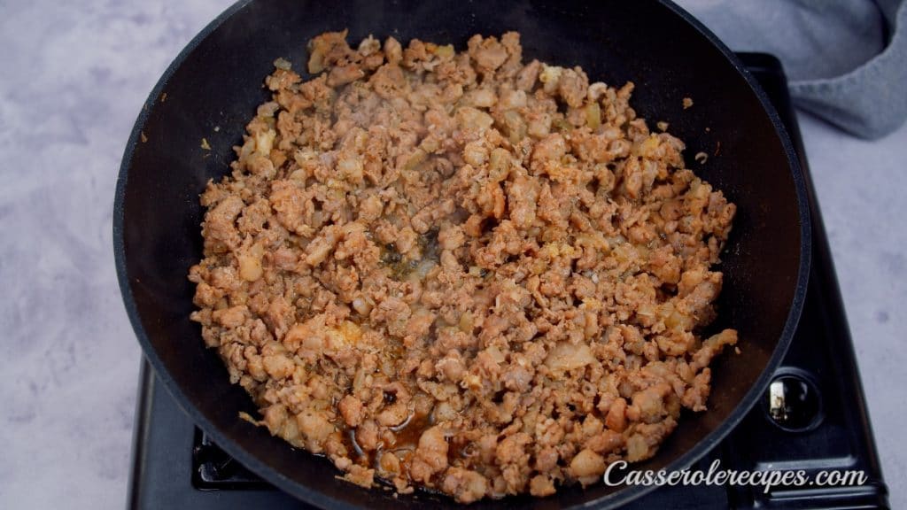 stirring browned sausage in a pan