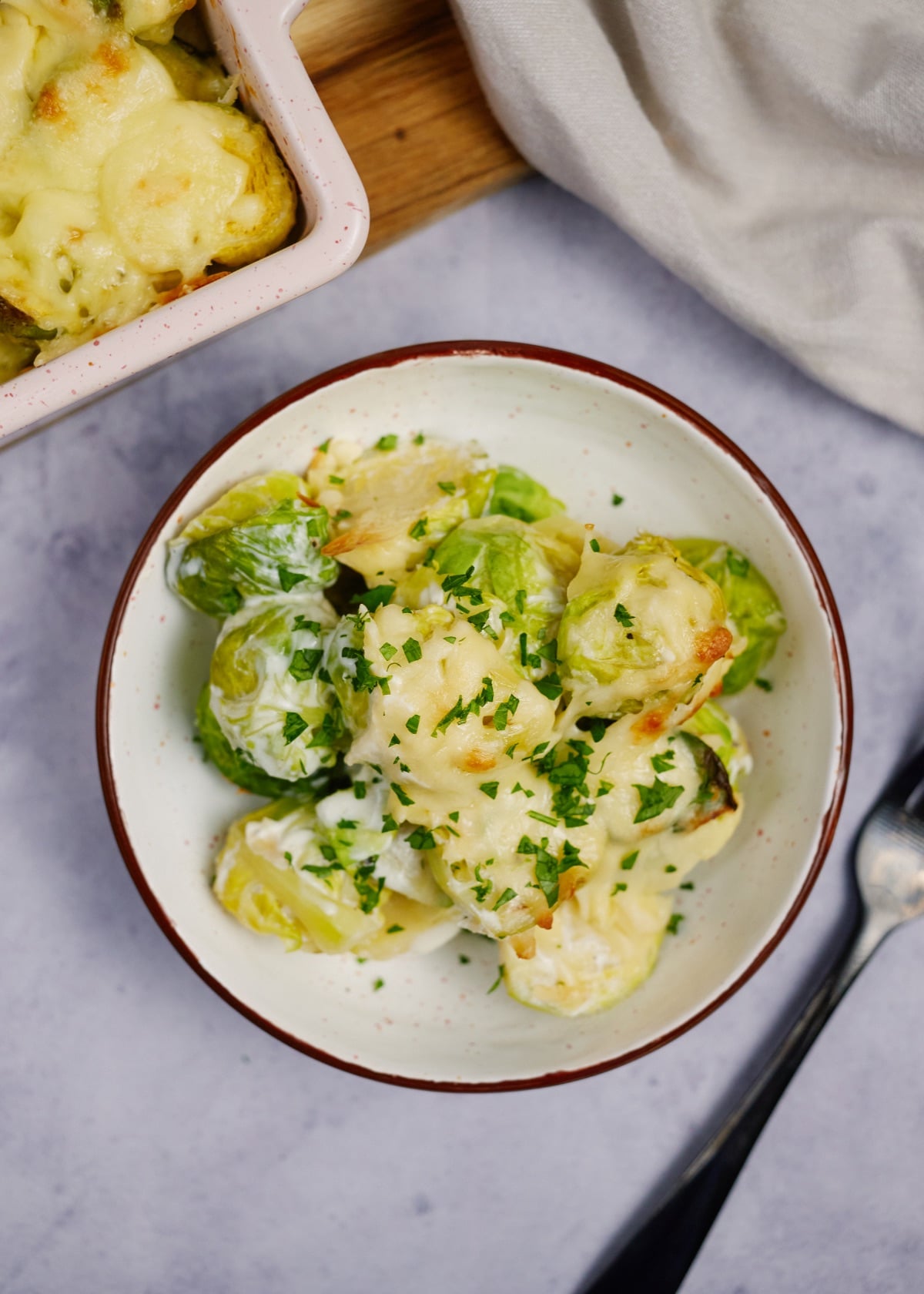 baked creamy brussel sprout casserole on a white plate