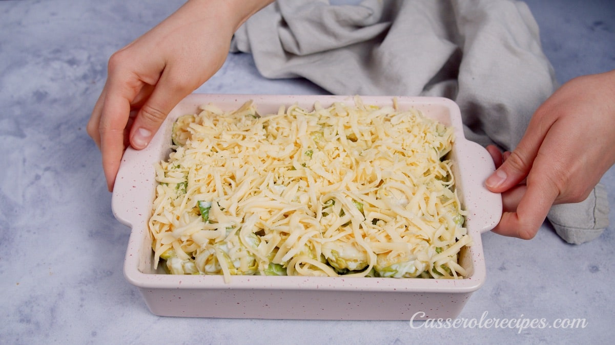 two hands holding baking dish with casserole