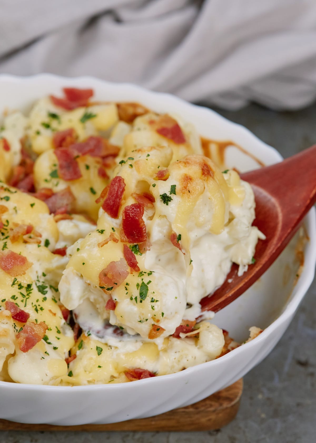 baked cauliflower casserole topped with chopped bacon in casserole dish