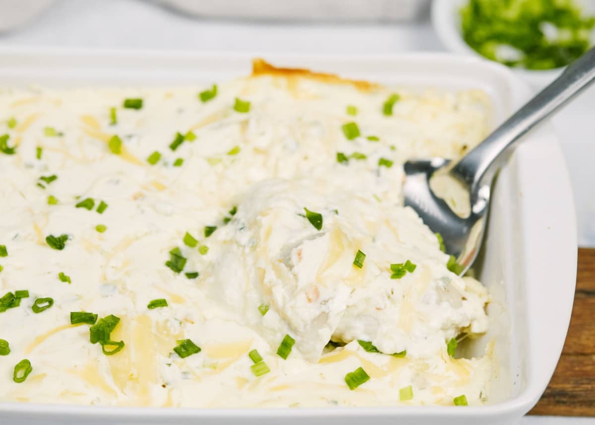 creamy pierogi casserole in a white baking dish on a white surface