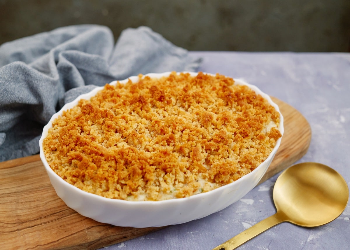 baked creamy ritz casserole in a baking dish on a wooden board