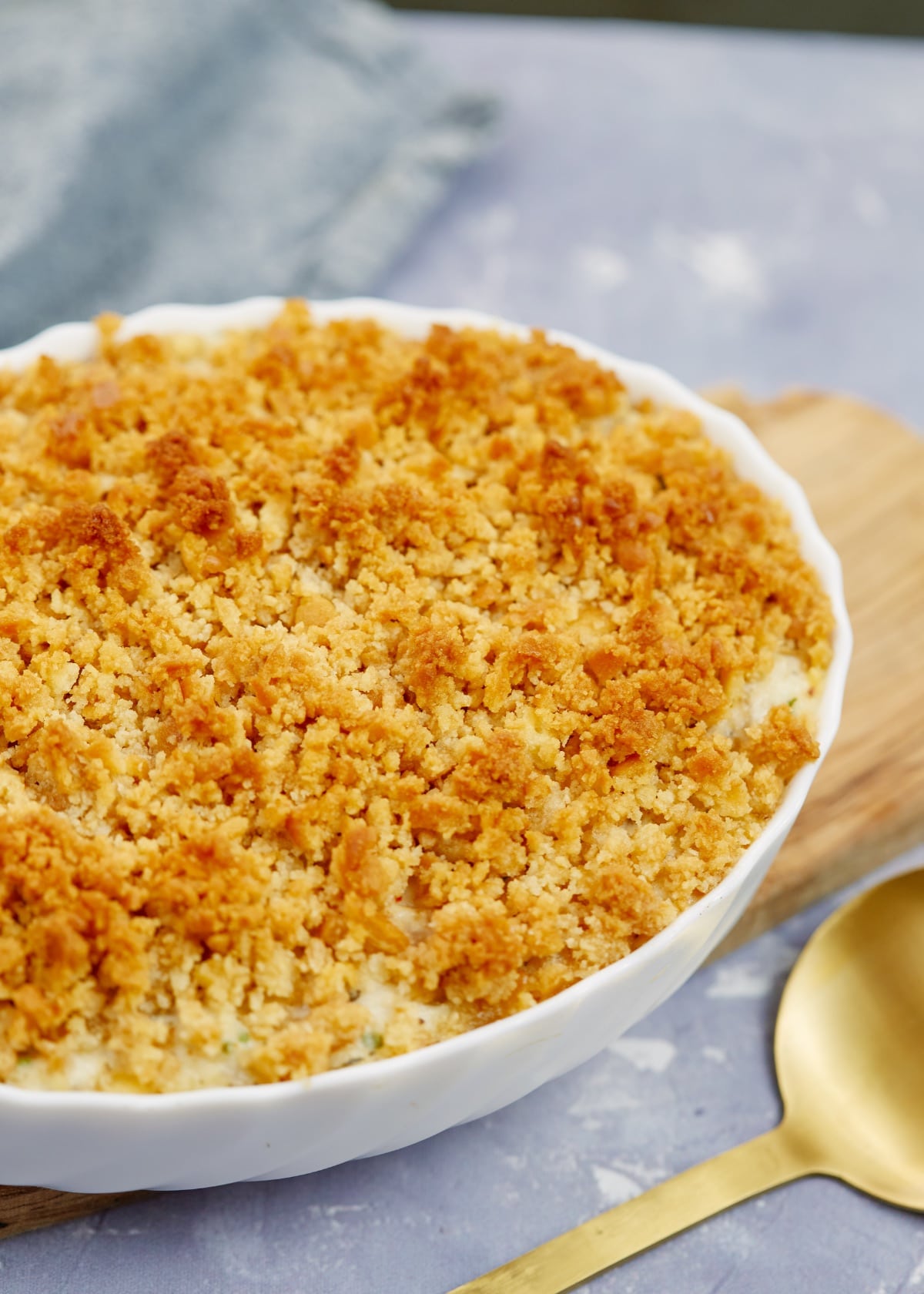 baked creamy ritz casserole in a baking dish on a wooden board