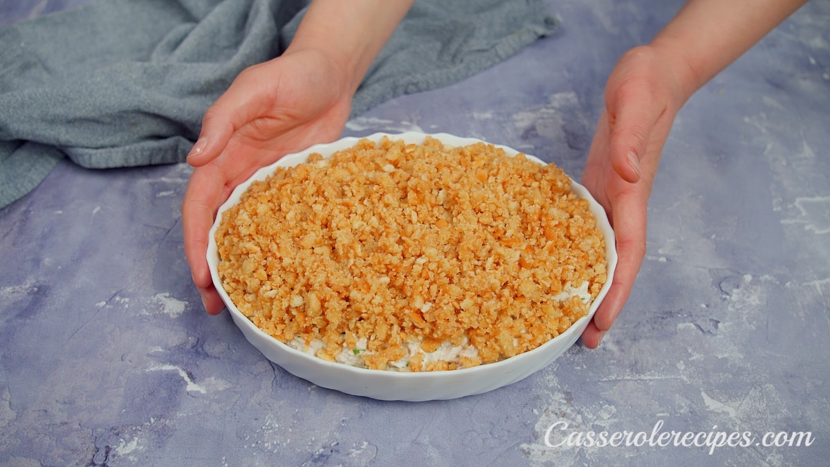 two hands holding baking dish with caserole