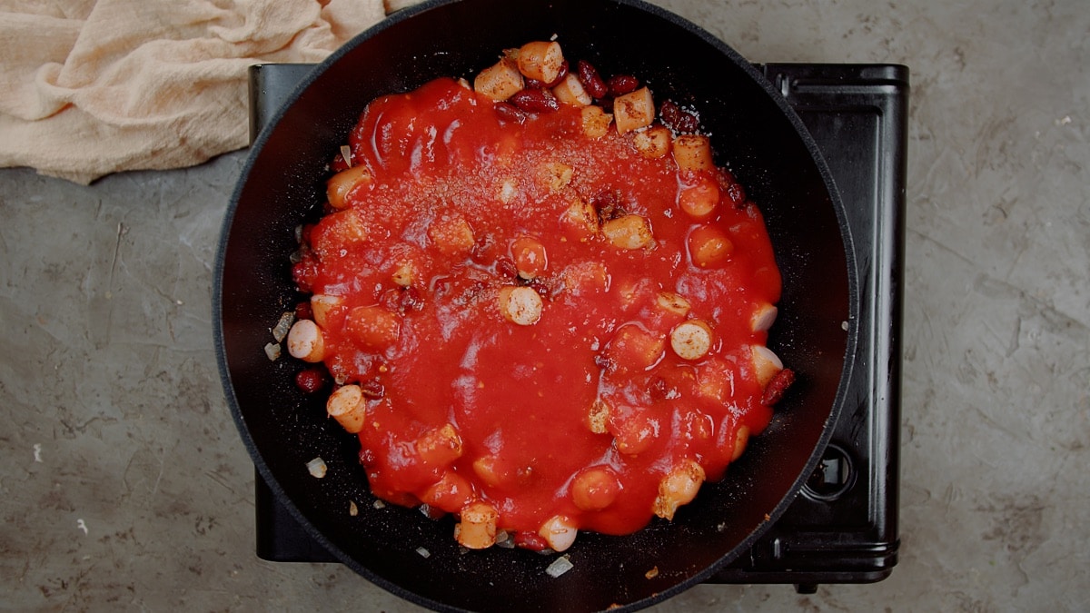 tomato sauce over hot dogs in saute pan