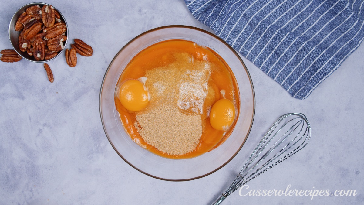 potato puree, brown sugar, and eggs in a clear glass bowl on a white surface