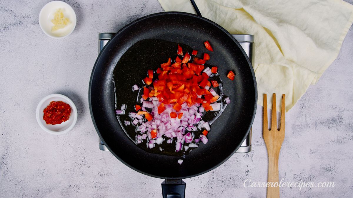 red bell pepper and red onion in black skillet
