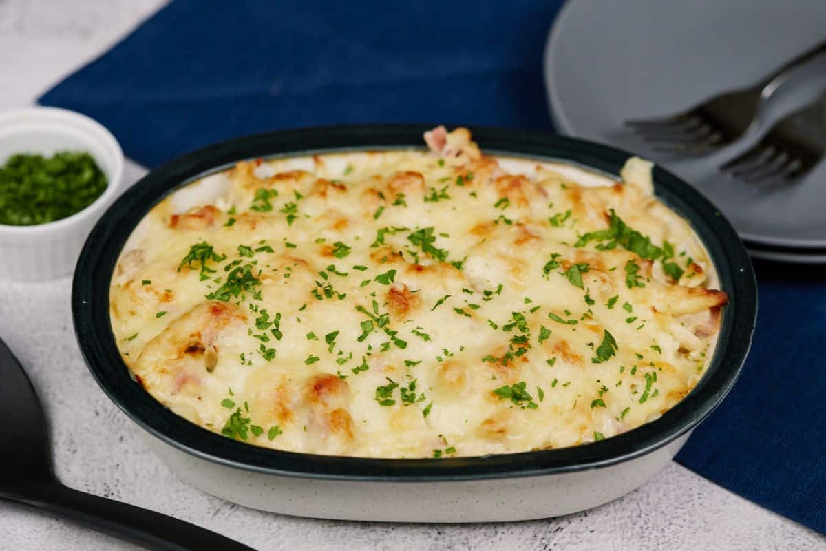 oval baking dish of chicken cordon bleu baked with parsley on top