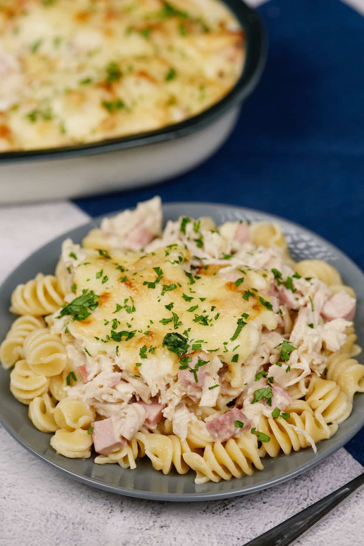 gray plate of chicken cordon blue casserole over pasta