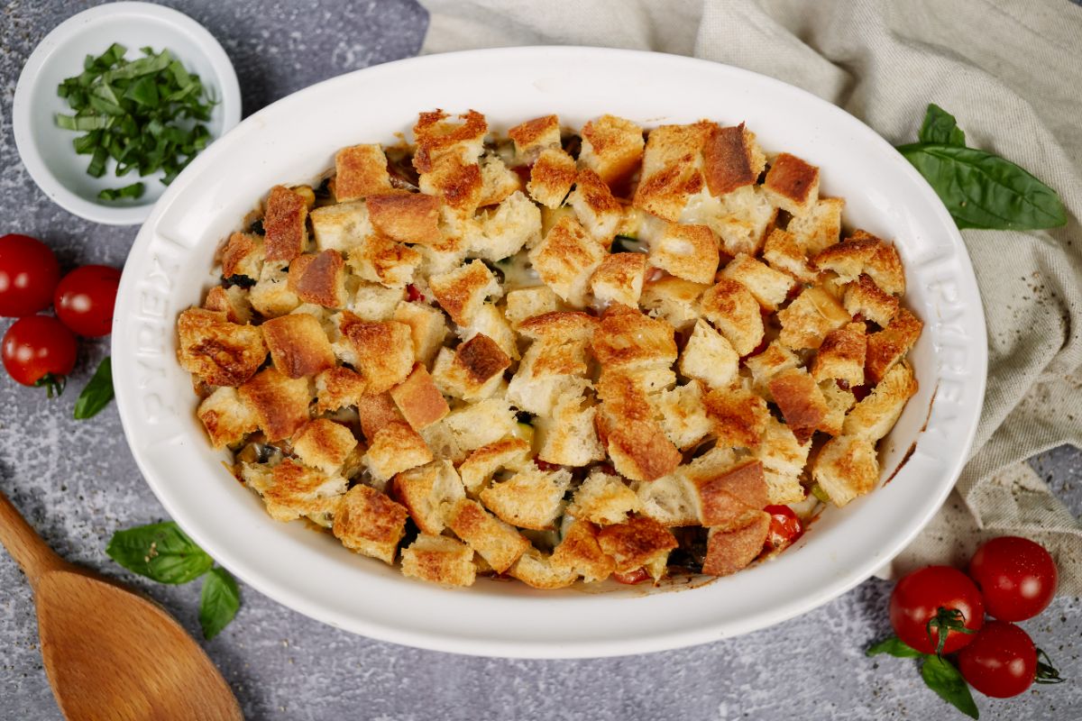 image looking down on oval white baking dish filled with casserole topped with croutons