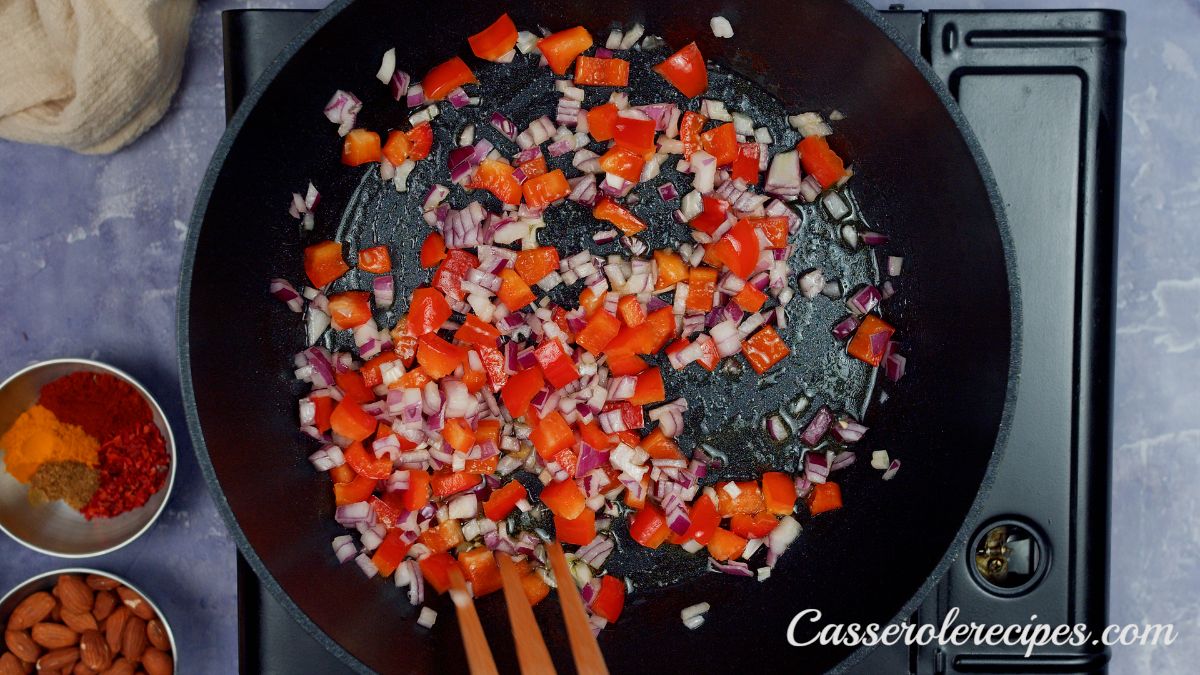 black skillet filled with peppers and onions sitting on hot plate